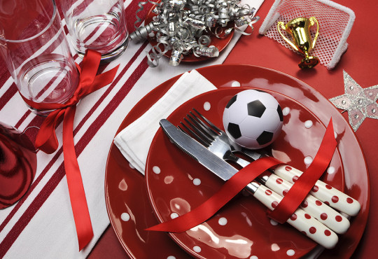 Red polkadotted plates on table with sports decorations