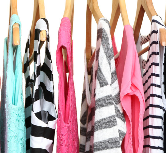 Colorful shirts on hangers hanging on rack
