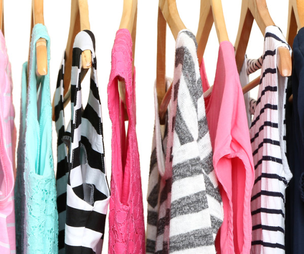 Colorful shirts on hangers hanging on rack