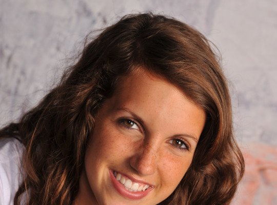 A girl smiling wearing a white shirt