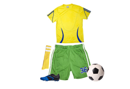 Yellow jersey, green athletic shorts, yellow socks, blue cleats, and soccer ball