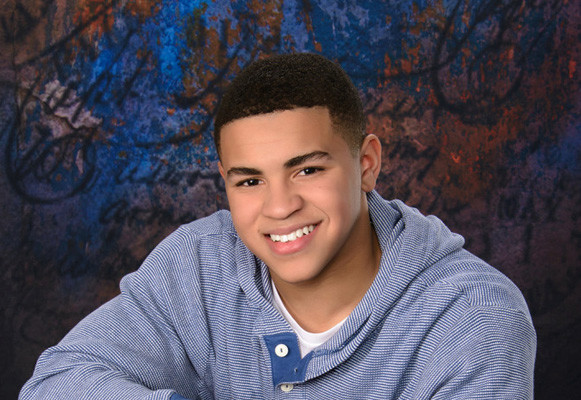 Boys Senior Portrait Chair Pose With Patterned Background
